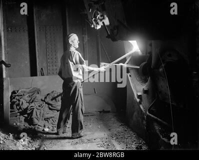 Der Heizer des Tramp-Dampfer, "SS Eston" schaufelt Kohle in den Kessel des Schiffes. 1935 Stockfoto