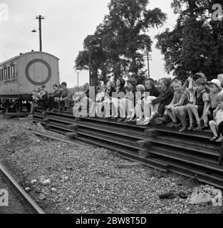 Kinder posieren für ein Foto auf einem Stapel von Eisenbahnschienen . 1936 . Stockfoto