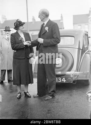 Herr Godfrey Mitchell, Konservativer (Kandidat der Nationalverwaltung) und Frau Janet Jennie Adamson, Kandidat der Labour Party, schütteln die Hände. Sie sind auf ihrem Wahlkampfweg für die Nachwahl in Dartford, Kent. 1938 Stockfoto
