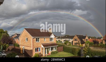 regenbogen Bögen über einem Haus an einem stürmischen Tag im Frühjahr in Großbritannien zweiten Regenbogen gesehen werden kann Stockfoto