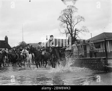 Die Royal Artillery Drag Hunt überqueren eine überflutete Straße in Eynsford, Kent. 1937 Stockfoto