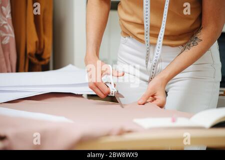 Nahaufnahme der Schneiderhand mit Schere Stockfoto