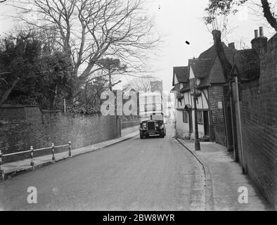 Ein Doppeldeckerbus fährt an einigen alten Hütten in einer Straße in Ashford, Kent vorbei. 11. Januar 1939 Stockfoto