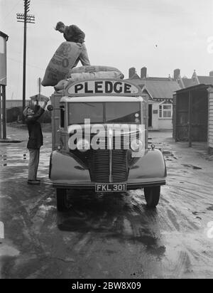 Arbeiter entladen Säcke von einem Bedford LKW von Pledge & Son Ltd, der Müllerei, auf einer ihrer Lieferungen in Ashford, Kent. 1939 Stockfoto