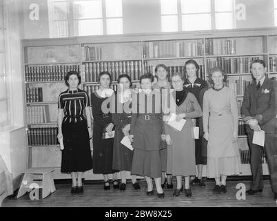 Ein Innenansicht der neuen Blackfen Library an der Cedar Avenue in Blackfen, London. Eine Gruppe posiert vor einem der Regale. 1937 Stockfoto