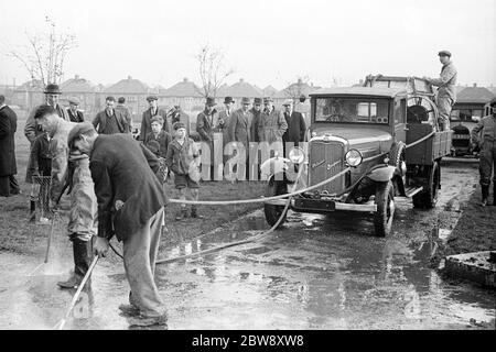 Pattisson Demonstrationen eines ARP-Lastwagens . Männer sind die Straße hinunter mit einem Bedford Pattisson ARP LKW, der geändert wurde, um einen Wassertank zu tragen, zu hocken. 1938 . Stockfoto