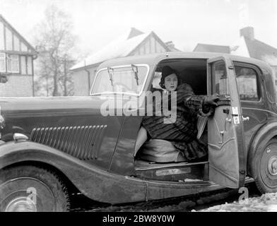 Miss Muriel Oxford sitzt auf dem Beifahrersitz eines Autos am Straßenrand. 1937 Stockfoto