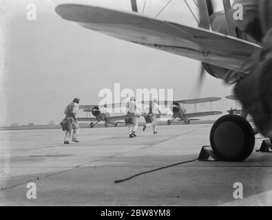 RAF Empire Air Day Probe, Biggin Hill, Kent. Piloten von 32 und 79 Geschwader laufen zu ihren wartenden gloster Stulpen Kämpfern auf dem Asphalt. 1937 Stockfoto