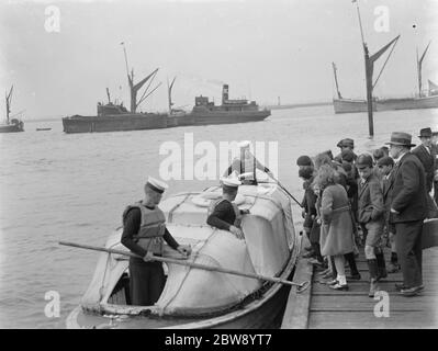 Die Heimatflotte auf der Themse in Greenhithe, Kent. Schulkinder auf einem schwimmenden Dock cue bis zu einem Boot zu besteigen. 1937 Stockfoto