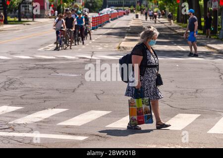 Montreal, CA - 30. Mai 2020 : Ältere Frau mit Gesichtsmaske zum Schutz vor COVID-19 auf Rachel Street Stockfoto