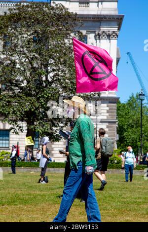 30. Mai 2020 London, UK - Extinction Rebellion inszeniert schweigenden sozial distanzierten Klimawandel-Protest in Westminster, Demonstranten, die von der Polizei wegen Verletzung der Coronavirus-Vorschriften bestraft und weggenommen werden Stockfoto