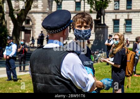 30. Mai 2020 London, UK - Extinction Rebellion inszeniert schweigenden sozial distanzierten Klimawandel-Protest in Westminster, Demonstranten, die von der Polizei wegen Verletzung der Coronavirus-Vorschriften bestraft und weggenommen werden Stockfoto