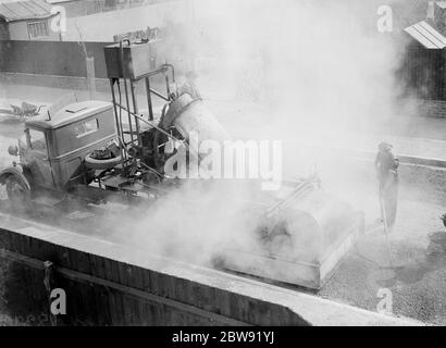 Val de Travers Asphalt Company Straßenbrenner in Aktion . Re - die Straße zu überwinden. 1938 Stockfoto