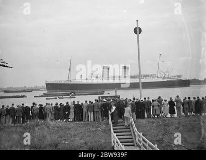 Menschenmassen versammeln sich am Ufer der Themse Mündung in Long Reach in Dartford, Kent, für eine Chance, die RMS Mauretania zu sehen. RMS Mauretania ist ein Ozeandampfer von Leonard Peskett entworfen und von Swan, Hunter & Wigham Richardson in Wallsend, Tyne und Wear für die British Cunard Line gebaut. 1939 Stockfoto