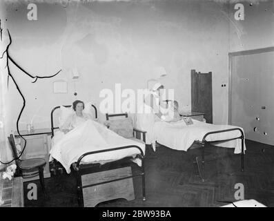 Das Sidcup Cottage Hospital in Kent. Eine Krankenschwester neigt zu einem Patienten in der Frauenabteilung. 1939 Stockfoto