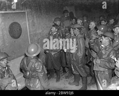 ARP ( Air RAID Vorsichtsmaßnahmen ) Arbeiter entspannen in ihren Gas Kontamination Anzüge spielen ein Spiel Darts . 1939 Stockfoto