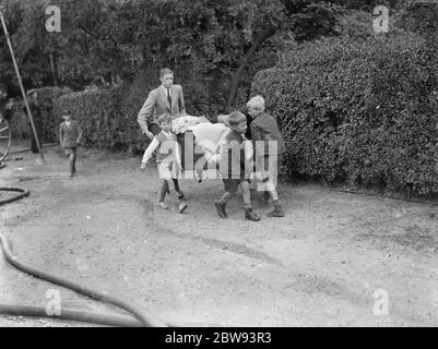 Feuerwehrleute reagieren auf ein Hausfeuer in Chislehurst, Kent. Einheimische versuchen und retten Möbel aus dem Haus. 1939 Stockfoto