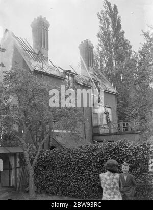 Feuerwehrleute reagieren auf ein Hausfeuer in Chislehurst, Kent. Feuerwehrschlauch Wasser in das obere Fenster des Gebäudes. 1939 Stockfoto