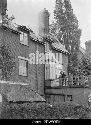 Feuerwehrleute reagieren auf ein Hausfeuer in Chislehurst, Kent. Eine Feuerwehr schlaucht Wasser in das obere Fenster des Gebäudes. 1939 Stockfoto