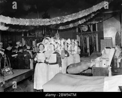 Chorknaben und Krankenschwestern singen Weihnachtslieder an Patienten im Erith Hospital in London. 1936 Stockfoto