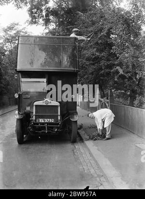 Wartungsmänner verwenden einen Doppeldeckerbus, um die überhängenden Äste oberhalb der Straße in Sidcup, Kent zu trimmen. 1937 Stockfoto