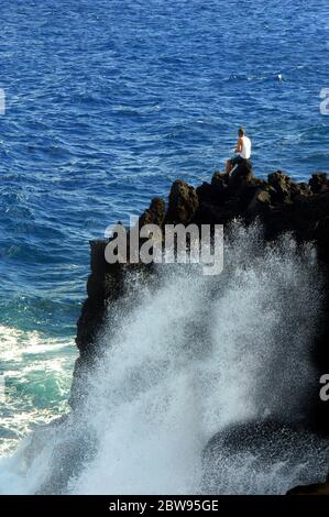 Lokale Fischer stehen am Rand einer Klippe im McKinzie State Park auf der Big Island von Hawaii. Er konzentriert sich auf die Fischerei und plant f Stockfoto