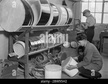 London 's großen Lärm, Drehen Schlagzeug durch die hundert. Trommeln , groß und klein , werden von den hundert in Acton , London , wo eine der größten Trommel Unternehmen Großbritanniens hat seine Fabrik . Qualifizierte Mitarbeiter kämpfen, um Sperrholz und Ferkel in die drms, die ihren Weg in Symphonieorchester und Jazz-Bands finden verwandeln. Die geringste Variation in der Kurve des Körpers oder die Spannung des Schweinshautes führt zu einem veränderten Ton und spezielle Zinnräume wurden gebaut, wo Anpassungen vorgenommen werden können, ohne den Rest des Personals übermäßig zu stören. Das Schweinsleder über den Plywoo legen Stockfoto