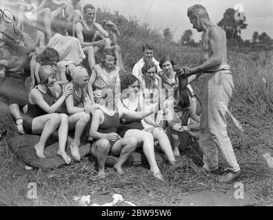 Wildjäger und Entdecker im Camp an der Themse. Captain Sarll, der große Wildjäger und Entdecker zeigt eine Party von Feriencamper in Shepperton, ein 10 Jahre alter Alligator, die er nach England von einer Wildjagd im Ausland gebracht. August 1932 Stockfoto