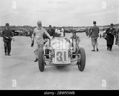 Rennen um British Empire Trophäe in Brooklands . Viele berühmte britische Rennfahrer Reihen sich am Start des British Racing Drivers Club , Empire Trophy Race , auf dem Brooklands Track , Weybridge , Surrey . Das Auto von Earl Howe angetrieben schieben seinen Einstieg in die Startlinie . 30. April 1932 Stockfoto