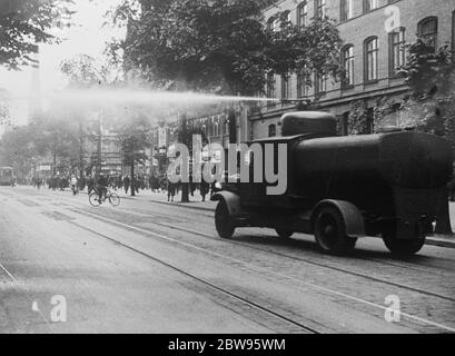 Die Polizei fährt mit Wasserbrötchen Randalierer aus Berliner Straßen. Mit mächtigen Wasserpistolen, montiert auf gepanzerten Lastwagen, fuhr die Polizei randalierenden Nazis und Kommunisten von den Straßen. Hunderte von Polizisten in Autos und Lastwagen wurden in die Vororte von Berlin, wo die Unruhen stattgefunden haben, eilig. Polizisten in Lastwagen werden zum Schauplatz der Störung in einem Vorort von Berlin gefahren. 27 Juni 1932 Stockfoto