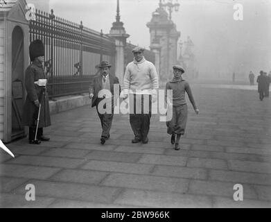 Carnera beginnt seine Ausbildung in London. Primo Carnera, der riesige italienische Boxer, trainiert in London für seinen Kampf am 17. März mit George Cook in der Royal Albert Hall. Carnera mit seinem Trainer Maurice Eudeline und seinem Manager Leon See, vorbei an der Wachposten am Buckingham Palace, während seiner frühen Morgenstunden draußen in London. 10 März 1932 Stockfoto