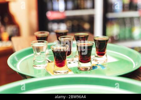 Mehrere Gläser von verschiedenen bunten Aufnahmen von Alkohol auf grünen Tablett legen Feier, Geburtstag, Party, Hochzeit Konzept. Stockfoto