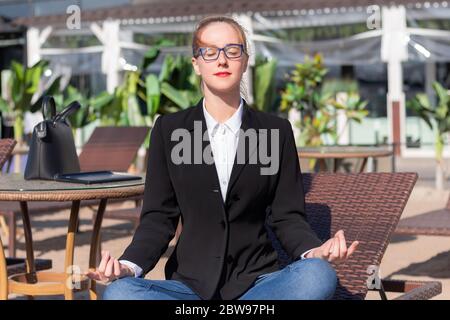 Büroarbeiterin sitzt in Yoga Lotus Pose zum Mittagessen Stockfoto