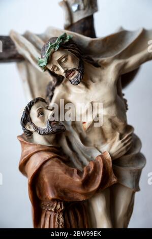 Statue des heiligen Franziskus von Assisi umarmt gekreuzigten Jesus. Eine private Kapelle. Slowakei, 2020/5/15. Stockfoto