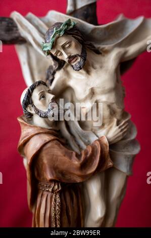 Statue des heiligen Franziskus von Assisi umarmt gekreuzigten Jesus. Eine private Kapelle. Slowakei, 2020/5/15. Stockfoto