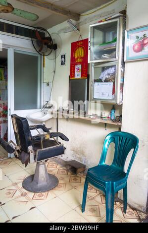 Hanoi, Vietnam - 21. Okt 2019: Straßenfriseure auf den Straßen Vietnams. Friseursalon. Alter Friseurstuhl Stockfoto