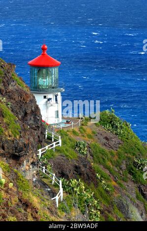 Zwei Arbeiter malen das Äußere des Makapuu Point Leuchtturms auf der Insel Oahu, Hawaii. Schäden durch Wind und Regen haben die Außenseite des erodiert Stockfoto