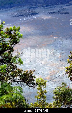 Puu Puai Krater wird von spärlicher Sonne beleuchtet. Der Weg führt über den Vulkanboden und winzige weiße Punkte sind Wanderer, die über den Kilauea Iki Trail in Hawa kreuzen Stockfoto