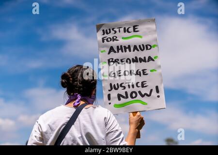 Protestierende im Pan Pacific Park im Fairfax District von Los Angeles, Kalifornien. Schild liest: "Gerechtigkeit für Ahmaud, Breonna, George, Gerechtigkeit jetzt!" Stockfoto