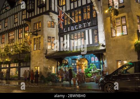 Das Liberty Kaufhaus im Londoner West End bei Nacht mit Weihnachtsbäumen draußen. Foto mit langer Belichtung. London Stockfoto