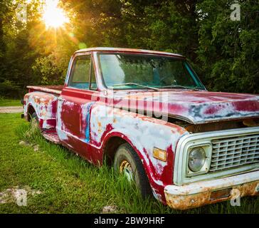 Antike rote LKW in einem Feld auf einem Bauernhof geparkt Stockfoto