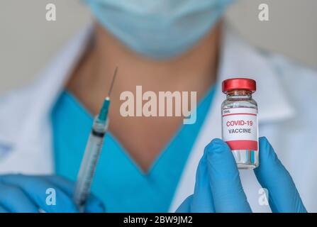 Nahaufnahme der Hände des Arztes mit Covid-19-Impfstoff und Spritze Stockfoto