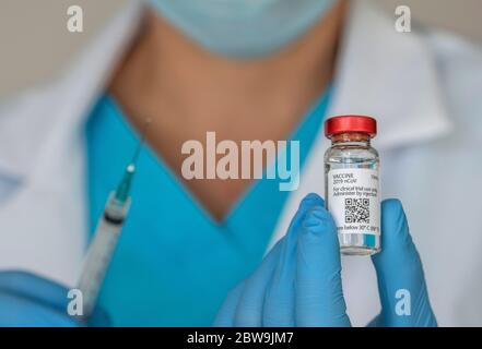 Close-upÂ von Ärzten Hände halten Covid-19-Impfstoff und Spritze Stockfoto