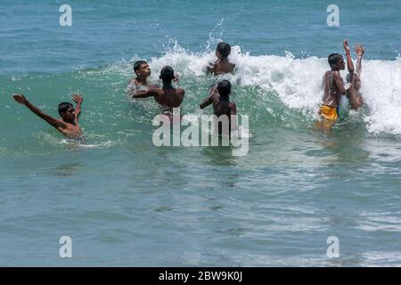 Eine Gruppe von Jungen genießen ein Bad im Meer in Arugam Bay an der Ostküste von Sri Lanka. Stockfoto