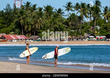 Ein Surferpaar schaut in Richtung der Point Break Wellen in Arugam Bay in Sri Lanka am frühen Morgen. Stockfoto