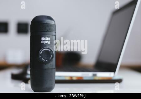 Ein illustratives Editorial der Wacaco Minipresso Maschine, in der Sie Espresso unterwegs im Home Office-Hintergrund zubereiten können. Stockfoto