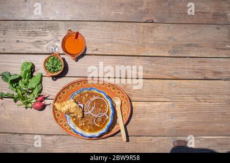 Blick von oben auf das mexikanische Essen mit Birria, Hot Sauce und Chicharron Stockfoto