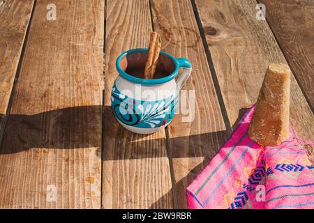 Mexikanischer Kaffee (Café de la olla) mit Zimt und braunem Zucker auf mexikanischem Serape Stockfoto