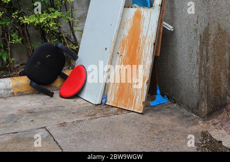 Closeup rote Rückenlehne aus verlassenen Kunstleder Stuhl umgedreht, weggeworfen am Straßenrand in der Nähe Müllplatz warten auf Recycling-Prozess Stockfoto