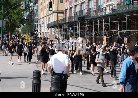 NEW YORK, NY - 30. MAI 2020: Protestierende marschieren und tragen am vierten Tag der Proteste gegen den Tod von George Floyd Zeichen. Stockfoto